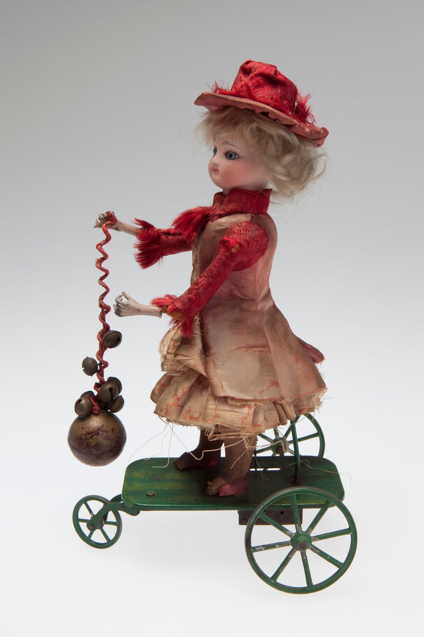 Mechanical Clockwork Doll on Metal Wheeled Platform that Rings a Bell and Turns Her Head as the Mechanism Turns
